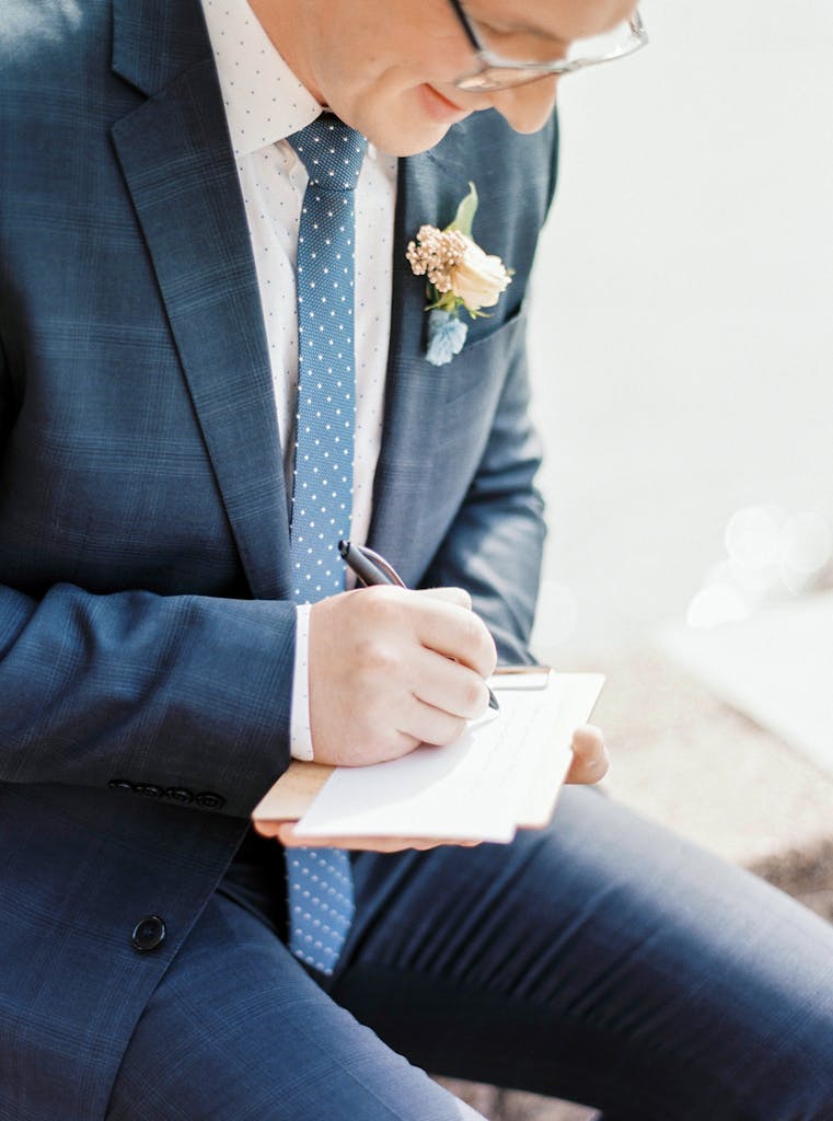 Groom in Suit Writing Vow in Notepad